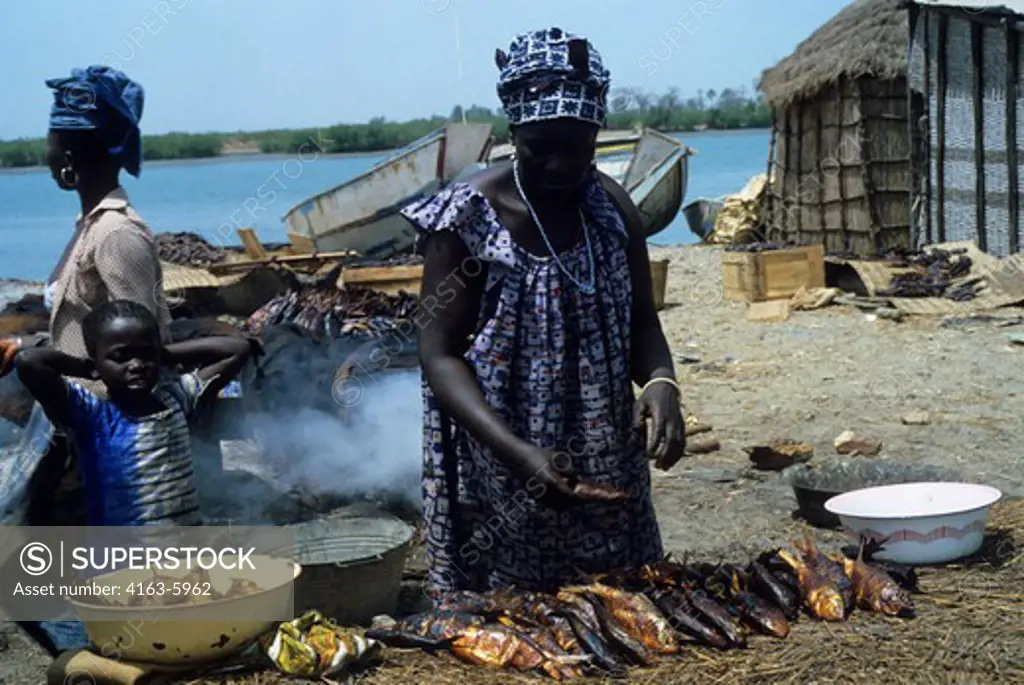 AFRICA, GAMBIA, GAMBIA RIVER, FISHING VILLAGE, WOMAN SMOKING FISH