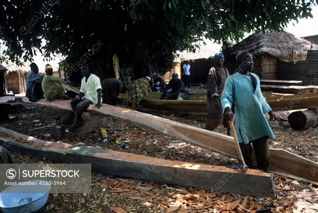 AFRICA, GAMBIA, GAMBIA RIVER, FISHING VILLAGE, CARVING DUG-OUT CANOES