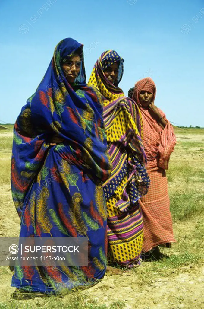 SENEGAL, THREE NOMAD WOMEN IN COLORFUL TRADITIONAL DRESS