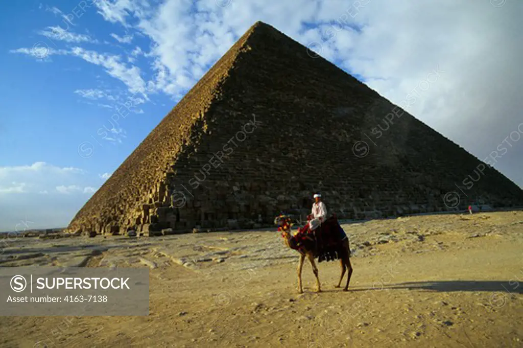 EGYPT, CAIRO, GIZA, CHEOPS PYRAMID WITH LOCAL MAN ON CAMEL