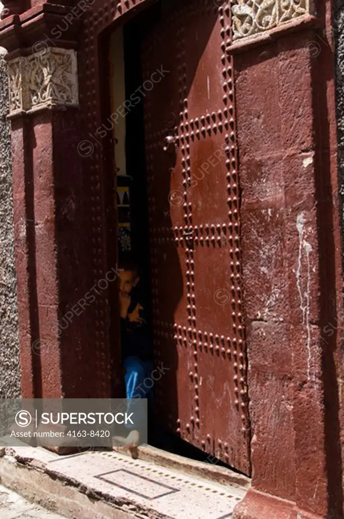 MOROCCO, CASABLANCA, STREET SCENE NEAR PALACE OF THE KING, LOCAL HOUSE, BOY PEEKING OUT OF DOOR