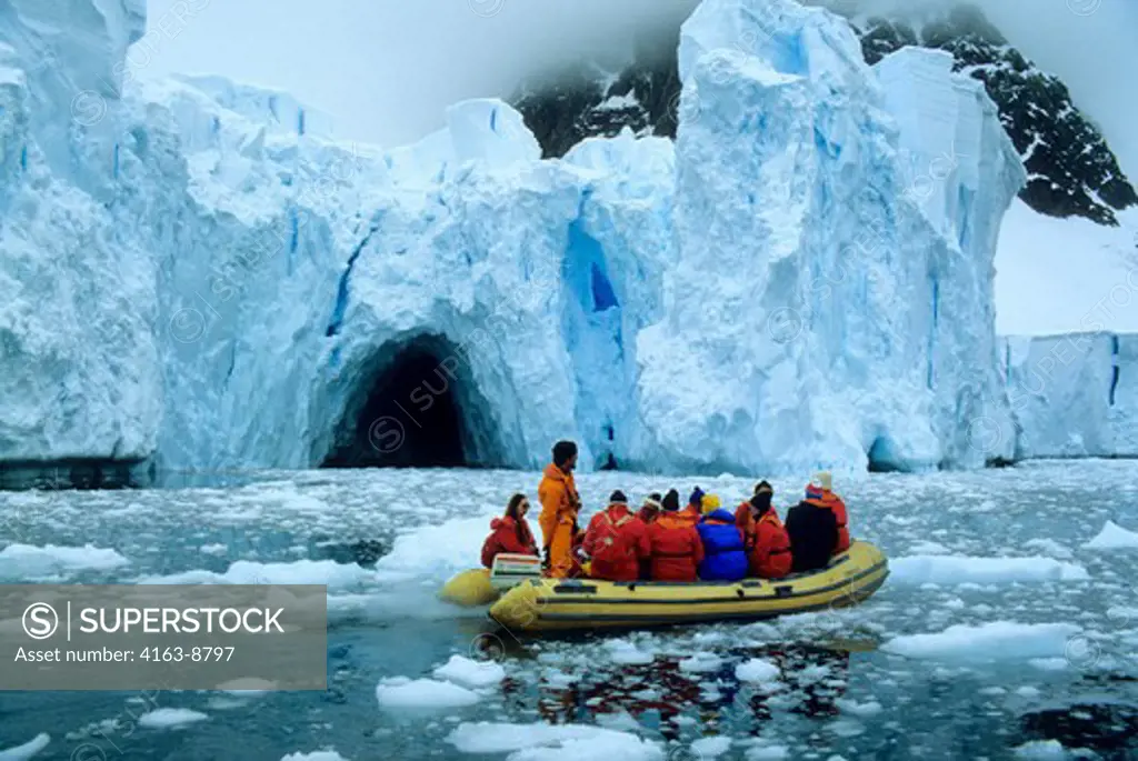 ANTARCTICA, TOURISTS IN RUBBER BOAT EXPLORING ICEBERGS AT PARADISE BAY