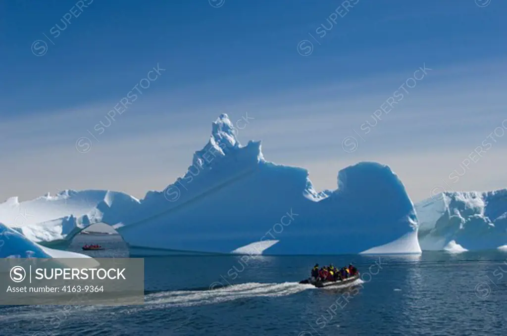 ANTARCTICA, ANTARCTIC PENINSULA,  ICEBERG WITH ARCH AT PALMER STATION (UNITED STATES RESEARCH STATION), TOURISTS IN ZODIACS
