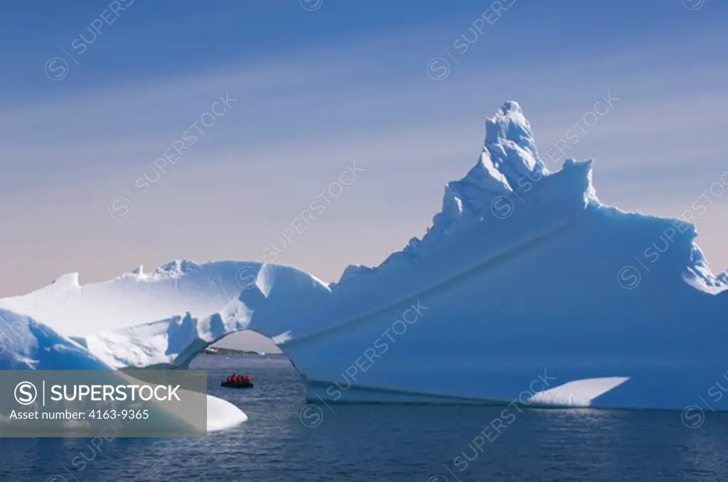 ANTARCTICA, ANTARCTIC PENINSULA,  ICEBERG WITH ARCH AT PALMER STATION (UNITED STATES RESEARCH STATION), TOURISTS IN ZODIAC