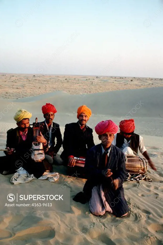 INDIA, RAJASTHAN, GREAT INDIAN (THAR) DESERT, NEAR JAISALMER, SAND DUNES IN EVENING LIGHT, LOCAL MUSCIANS