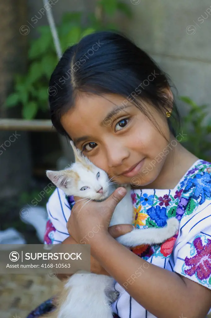 Guatemala, Highlands, Near Antigua, Santa Catarina Barahona, Mayan Girl In Traditional Dress, 5 Years Old With Pet Cat