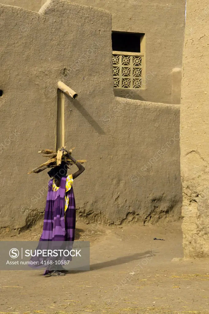 Mali, Djenne, Street Scene Woman Carrying Firewood On Back