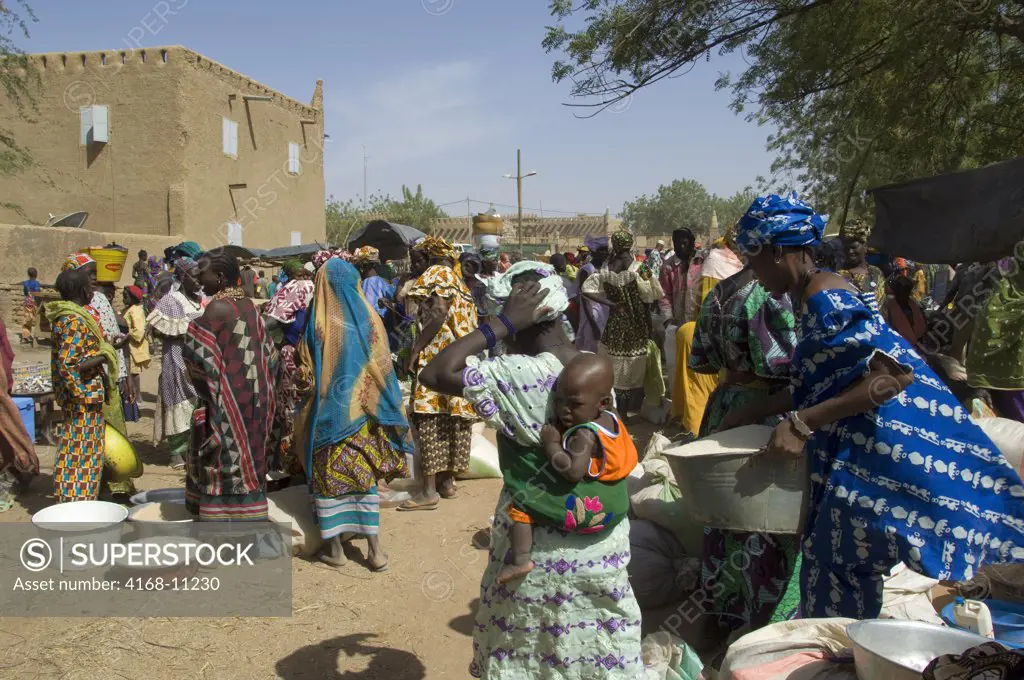 Mali, Djenne, Weekly Market In Square In Front Of Mosque, Market Scene With Mother Carrying Child In Sling On Back