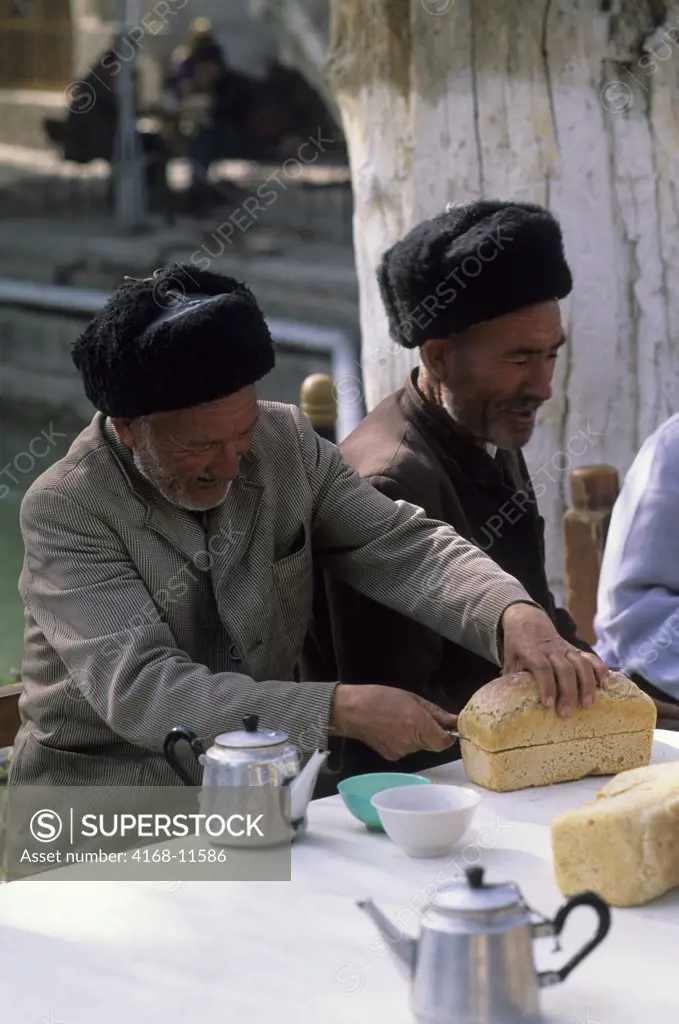 Uzbekistan, Bukhara, Tea House, Man Cutting Bread