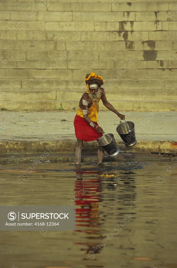 India, Varanasi, Ganges River, Holy Man Taking Water Out Of River