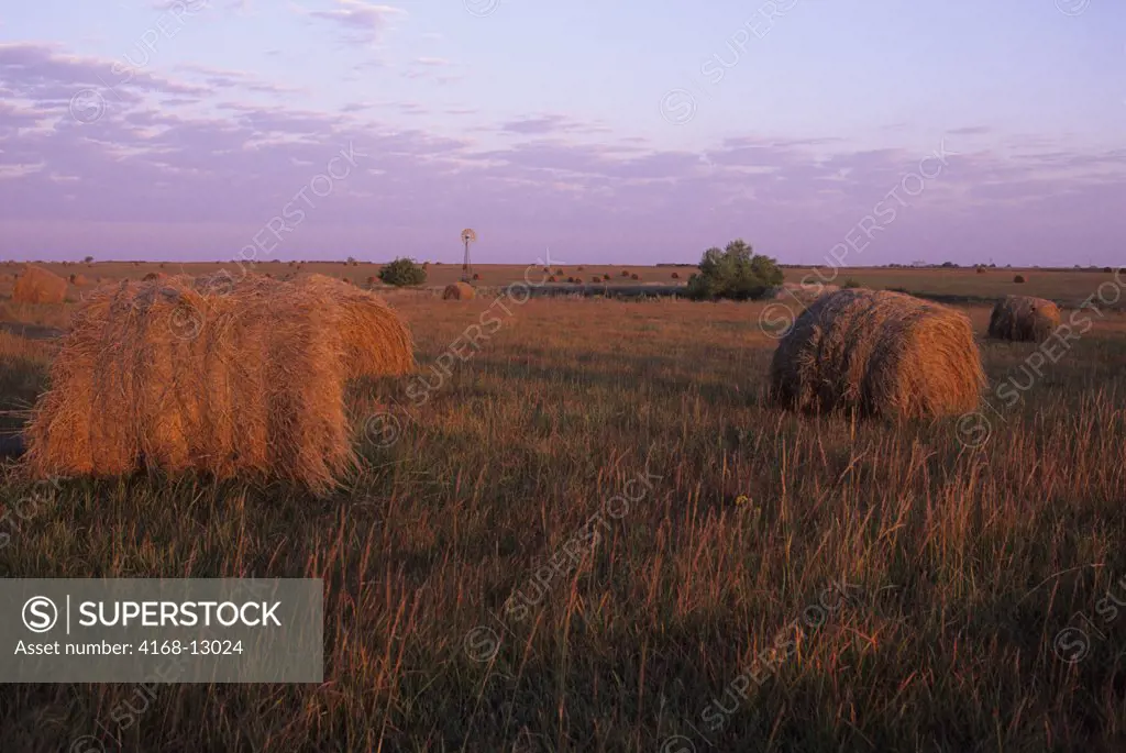 USA, Kansas, Flint Hills, Near Alta Vista, Highway 177, Tallgrass Prairie, Hay Bales In Sunset With Windmill In Background