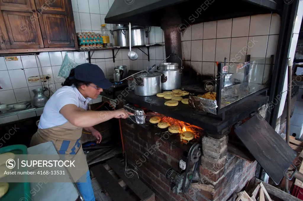 Woman In Small Roadside Restaurant Cooking Arepas (Favorite Colombian Snack) In La Calera, Near Bogota, Colombia