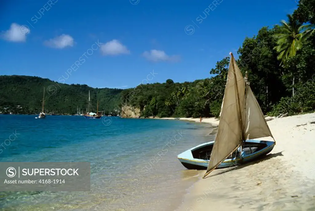 CARIBBEAN, BEQUIA, TROPICAL BEACH WITH SMALL SAIL BOAT PULLED ASHORE