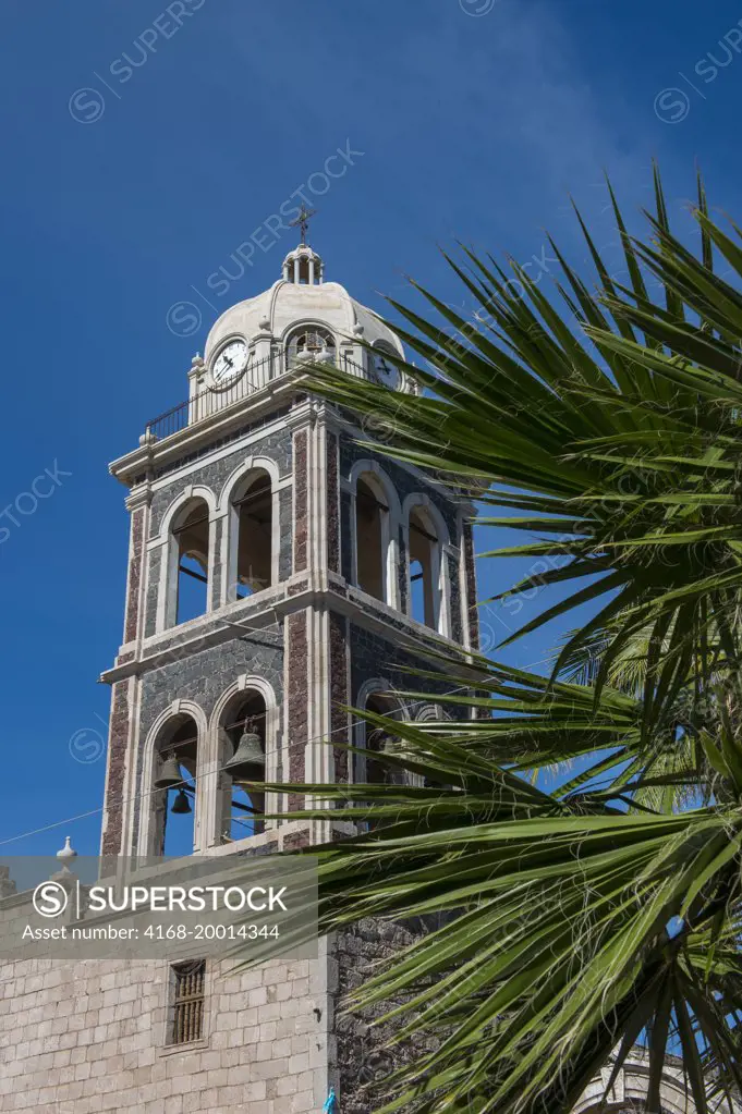 The tower of the Jesuit Mission built in 1697, with palm trees in the foreground in Loreto in Baja California, Mexico.