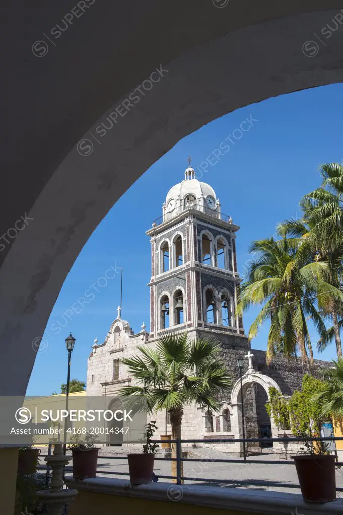 The tower of the Jesuit Mission built in 1697, with palm trees in the foreground in Loreto in Baja California, Mexico.