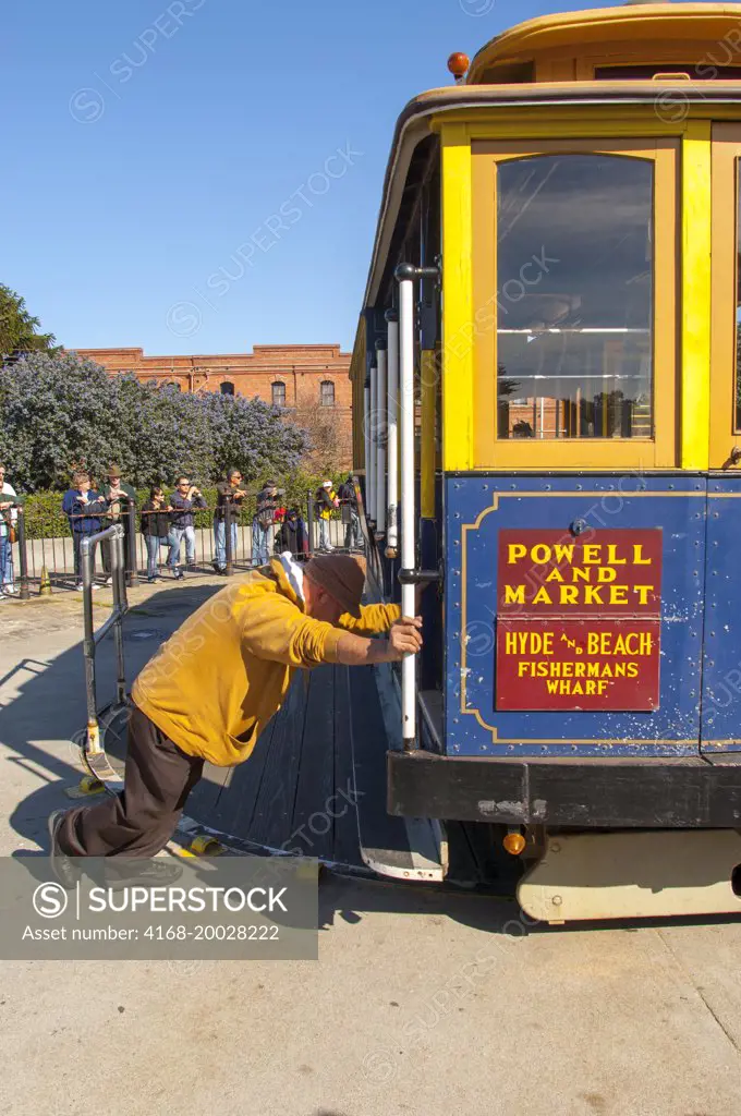 A cable car trolley is being turned around on a turntable in San Francisco, California, USA.
