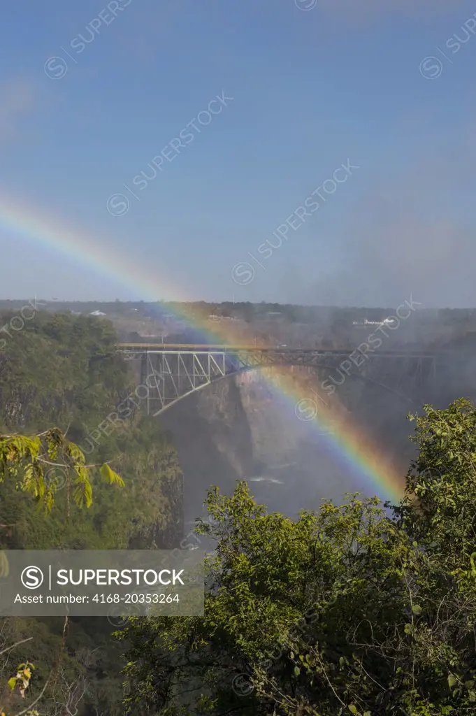 View from Zambia of Victoria Falls Bridge between Zambia and Zimbabwe with rainbow in the spray of the falls.