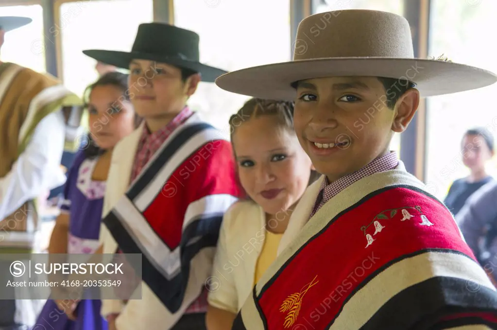 Local children in traditional costumes in Puerto Chacabuco in the Chilean Fjords in southern Chile.
