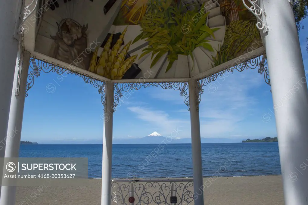 Pavilion on lakeshore in Frutillar, a small town on Lake Llanquihue in the Lake District near Puerto Montt, Chile with Osorno Volcano in background.