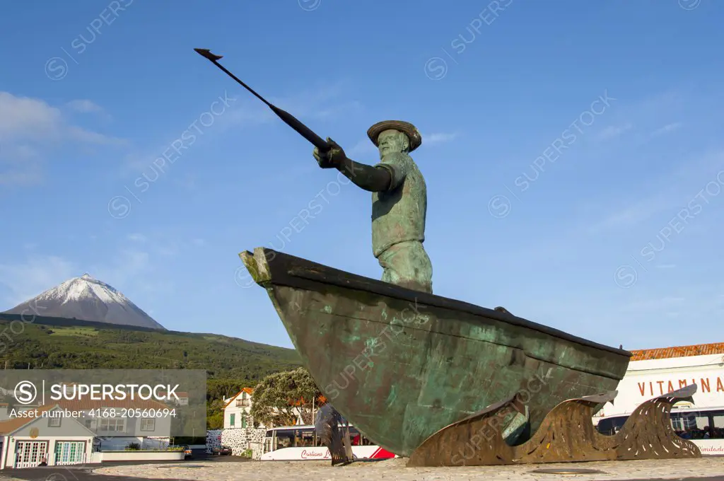 The monument to the whalers at the whaling museum in Sao Roque do Pico on Pico Island in the Azores, Portugal, with Pico Volcano in the background.