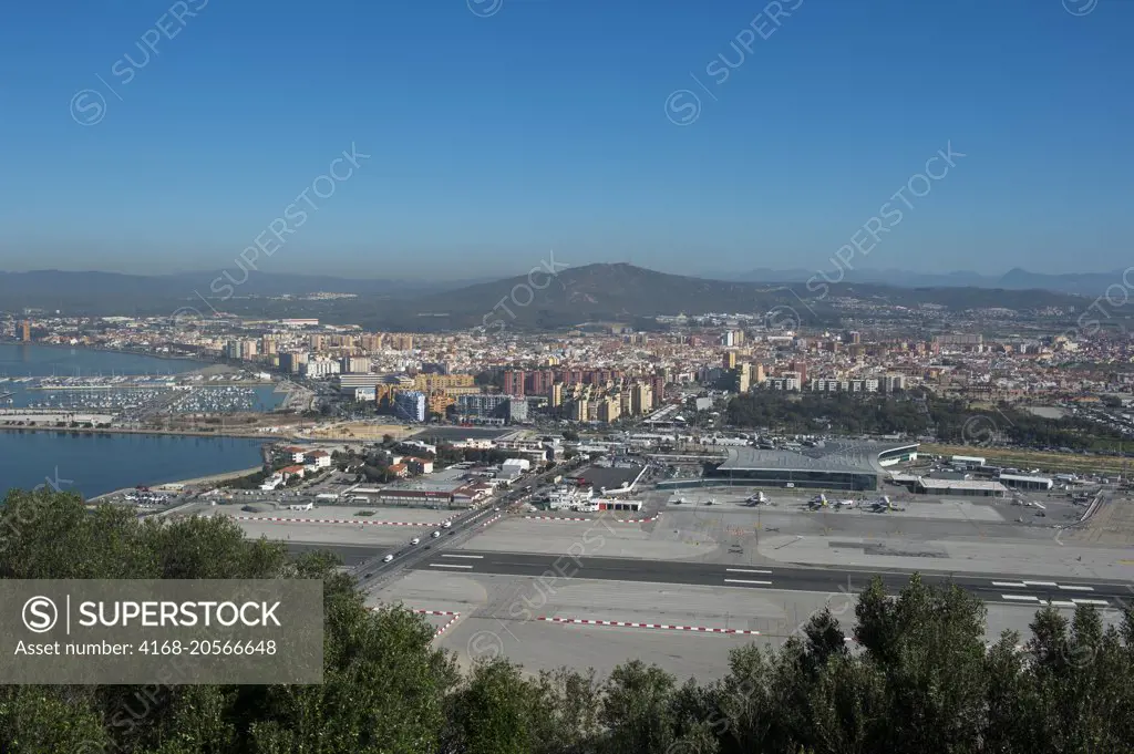View of the airport and Spain from the Rock of Gibraltar, which is a British Overseas Territory, located on the southern end of the Iberian Peninsula at the entrance of the Mediterranean.