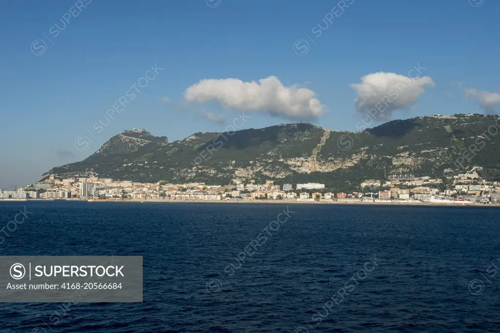 View of the city and the Rock of Gibraltar from sea, which is a British Overseas Territory, located on the southern end of the Iberian Peninsula at the entrance of the Mediterranean.