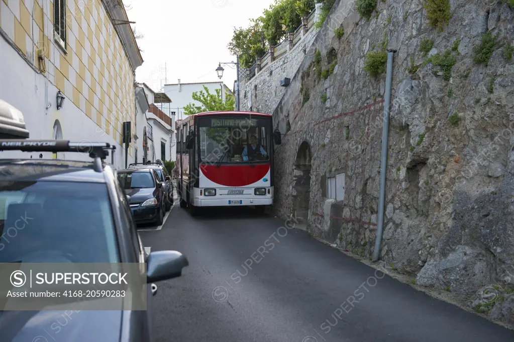 A bus on the coastal road along the Amalfi Coast which is very narrow as seen here in Praiano, a community of the province of Salerno in the Campania region of southwest Italy.