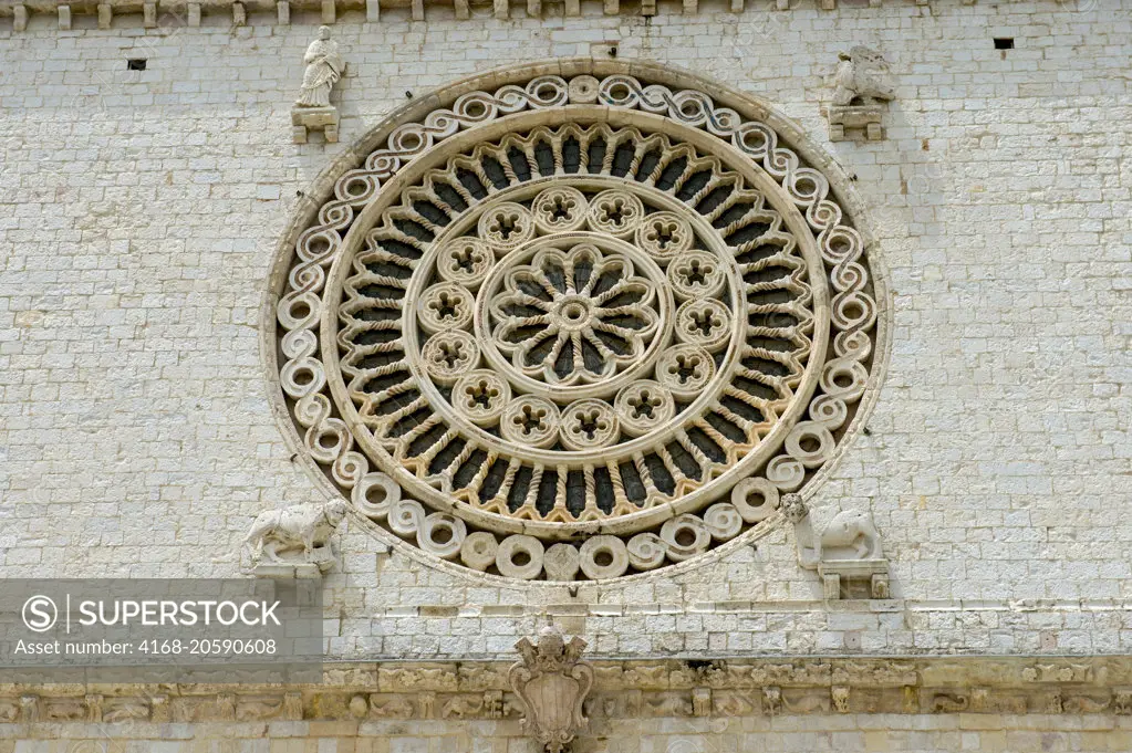 Detail of the facade with the rose window of the Papal Basilica of St. Francis of Assisi is the mother church of the Roman Catholic Order of Friars Minor, commonly known as the Franciscan Order, in Assisi, Italy.