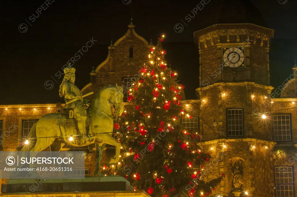 The equestrian statue of Jan Wellem illuminated at night and Christmas decorations in front of the old town hall in the old town of Dusseldorf, Germany.