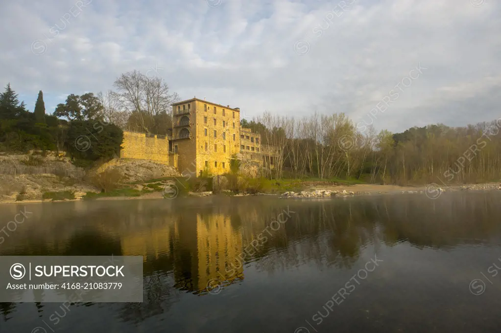 View of a building on the Gardon River on a foggy morning at the Pont du Gard in the south of France.