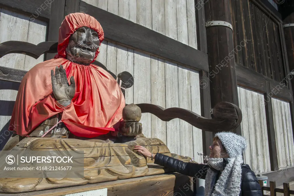 A wooden statue of Binzuru Pindola in front of the Great Buddha Hall of the Todai-ji (Eastern Great Temple), which is a Buddhist temple complex located in the city of Nara, Japan (Model Release 20020923-10).