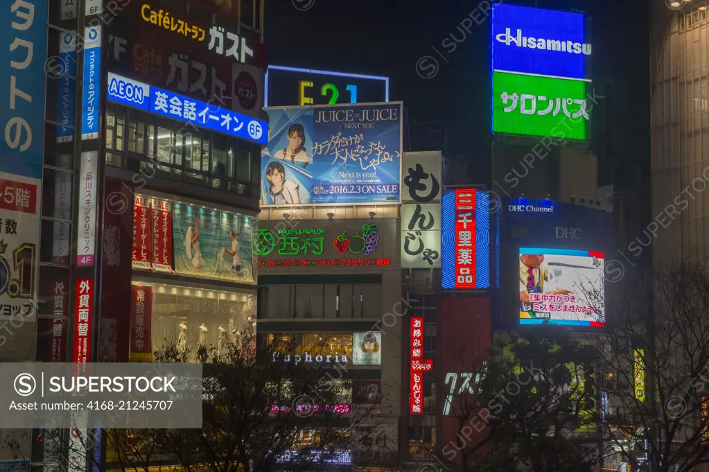 View at night of the colorful advertisements at Shibuya Station in Tokyo, Japan.