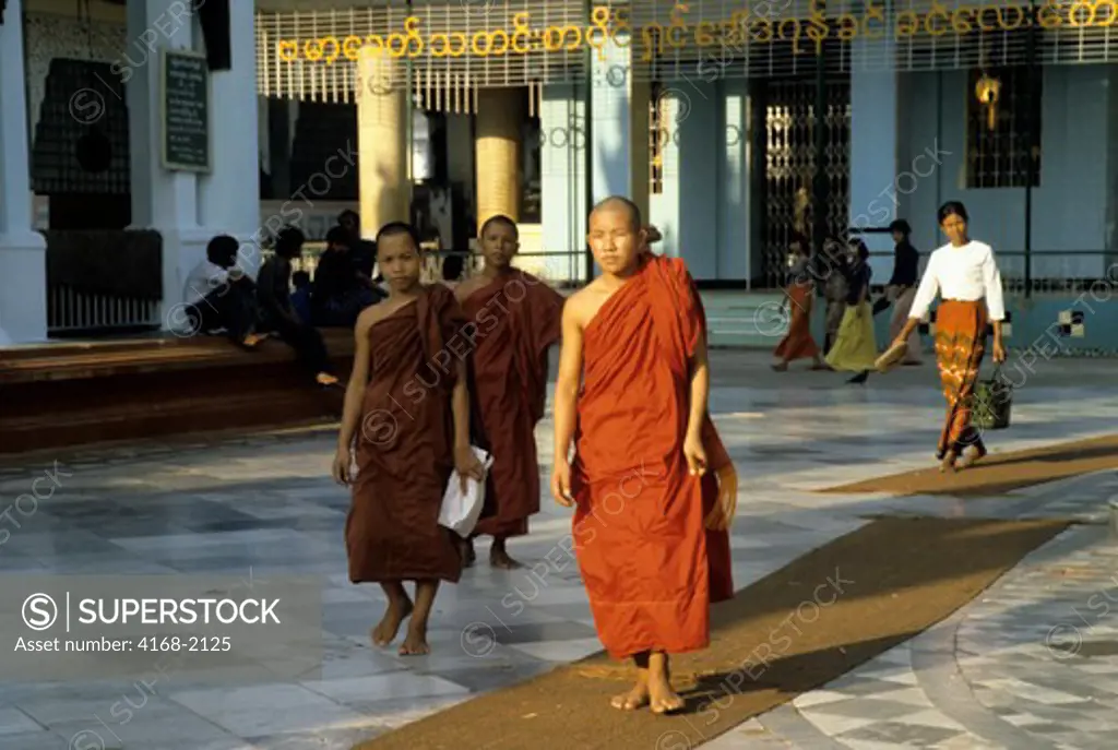 Burma, Rangoon Swedagon Pagoda, Monks In Saffron Robes Walking Through Temple Grounds