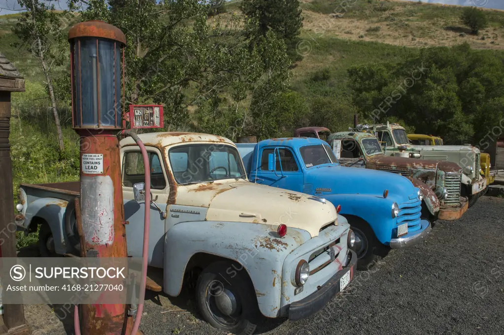 Antique gas pump and cars at an old gas station, part of an old car collection at a farm near Colfax in Whitman County in the Palouse, Washington State, USA.