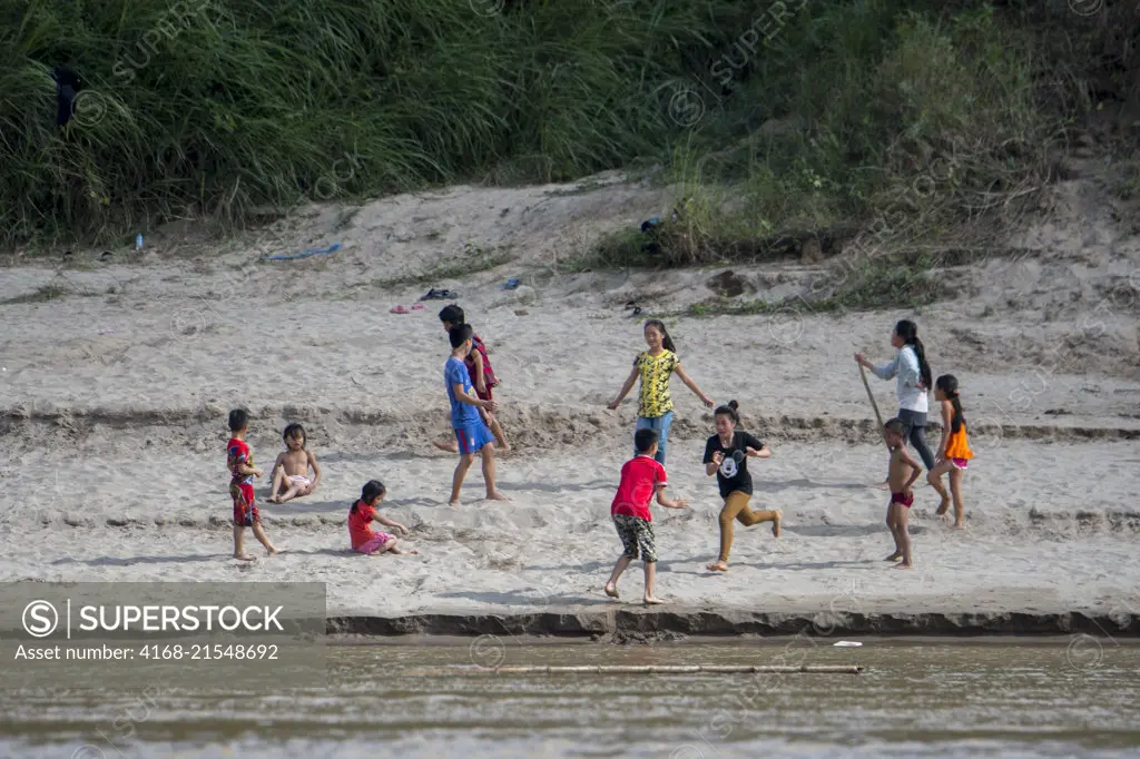 Children playing on the riverbank of the Mekong River near Luang Prabang in Central Laos.