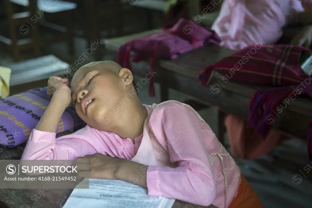 An elementary girl student fell asleep in the classroom at the public school of the Aungmyazoo Monastary in Sagaing, a town outside of Mandalay, Myanmar.