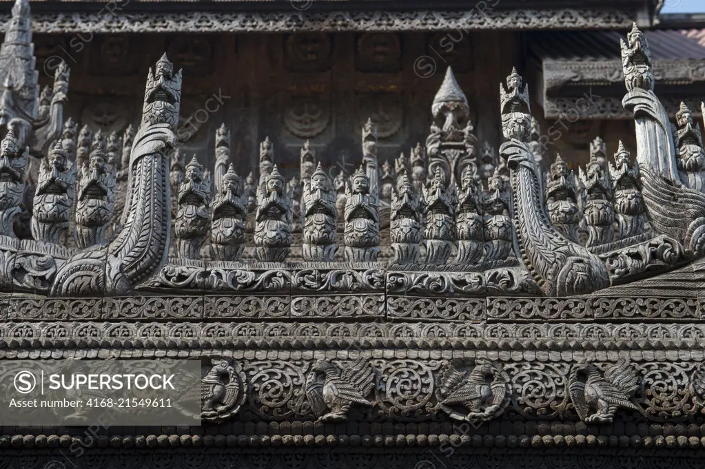 Detail of the teak carvings of guardians at the Shwenandaw Monastery (Golden Palace Monastery) in Mandalay Hill, which was built in 1880 by King Thibaw Min with originally parts of the royal palace at Amarapura in Myanmar.