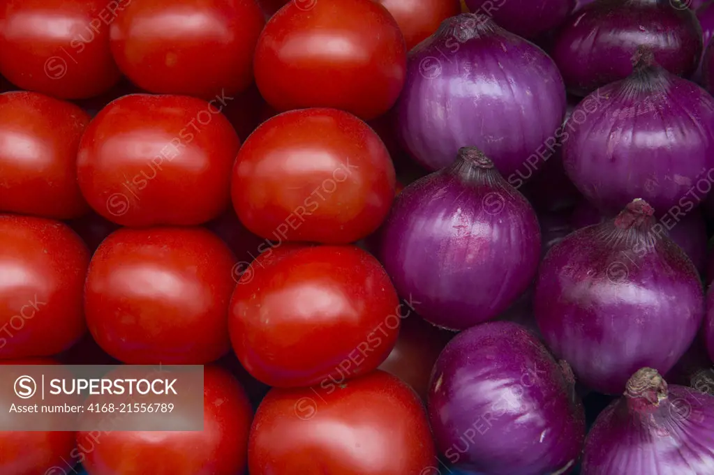 Tomatoes and onions for sale on the local food market in the town of Otavalo in the highlands of Ecuador near Quito.