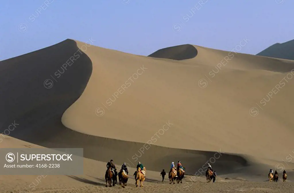 China, Gansu Province, Dunhuang, Sand Dunes, Tourists Riding Bactrian Camels