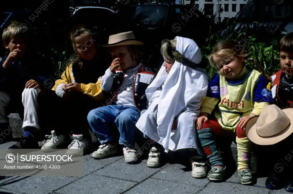Norway, Alesund, Local Children Sitting On Wall