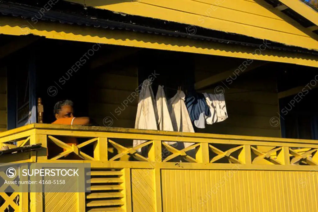 honduras, roatan island, coxen's hole, street scene, woman on balcony