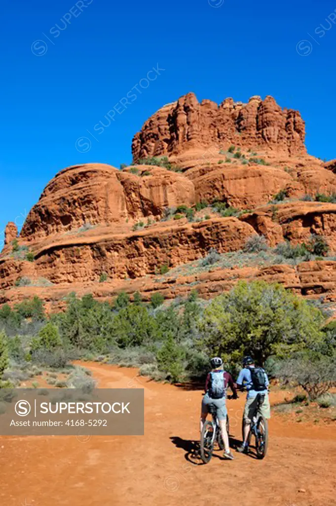 usa, arizona, sedona, bell rock/courthouse loop trail, view of red rock formations, bell butte with mountain bikers