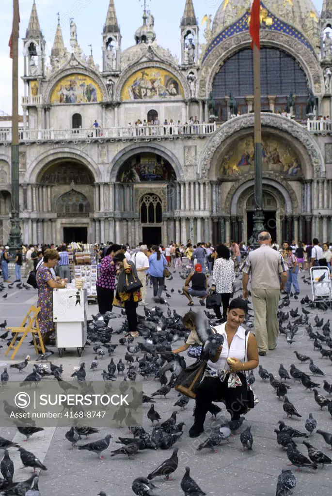 Italy, Venice, San Marco Quarter, St, Mark's Square, St. Mark's cathedral, Tourist feeding pigeons