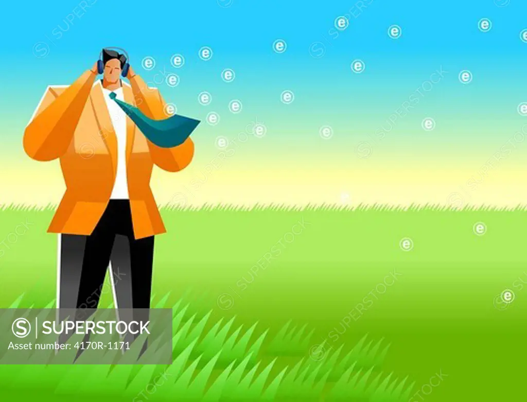Businessman standing in a field and listening to music
