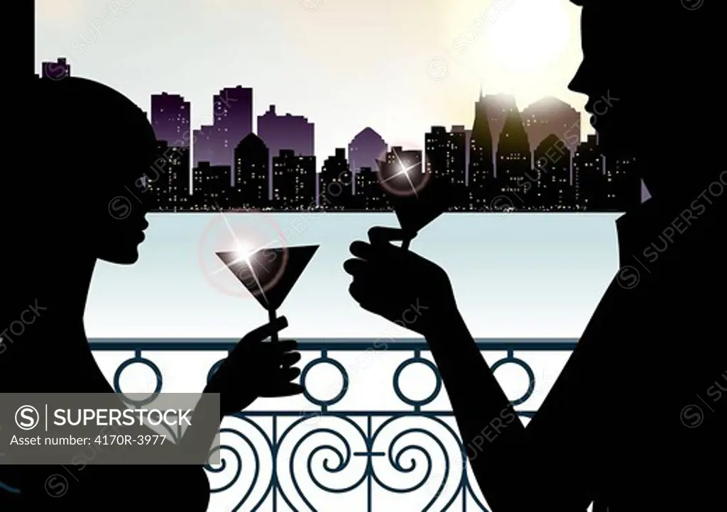 Silhouette of a couple toasting with martini glasses