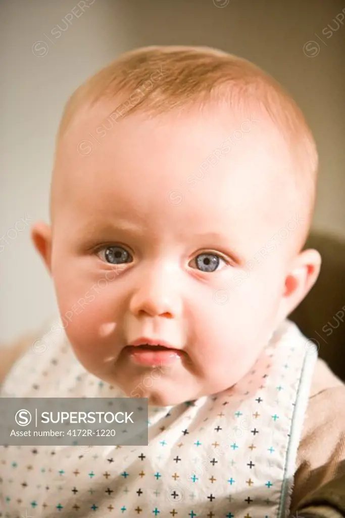 Close up of baby with blue eyes wearing bib