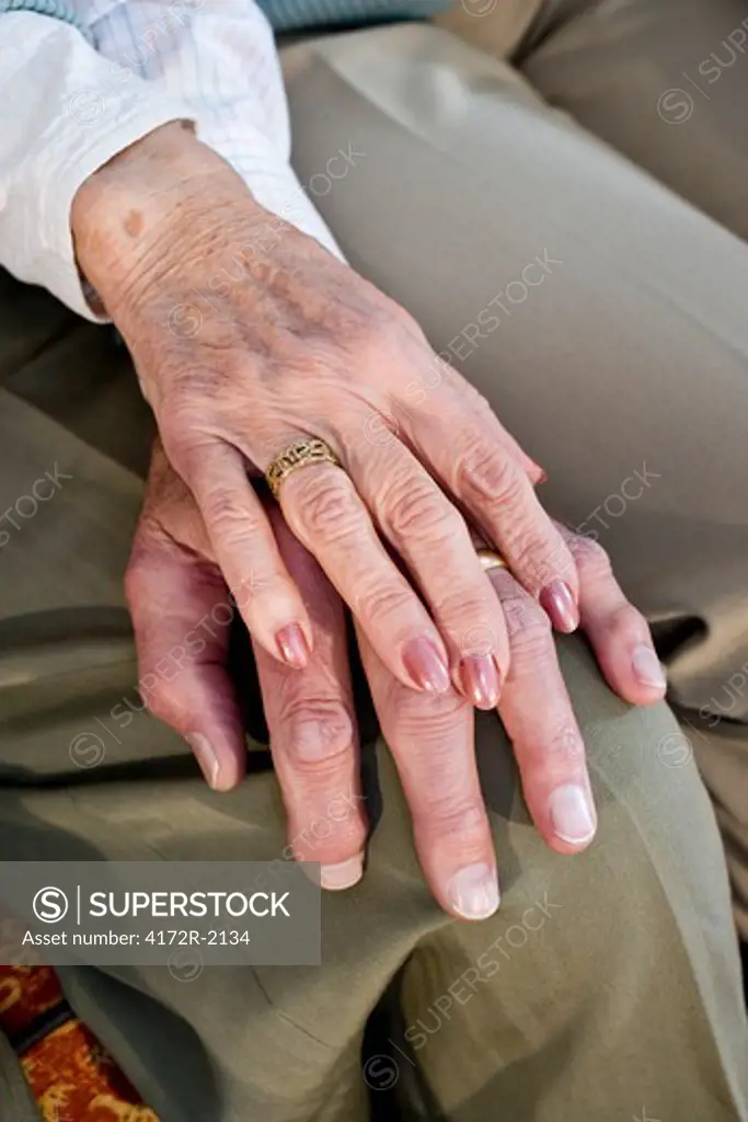 Close-up hands of senior couple resting on knee