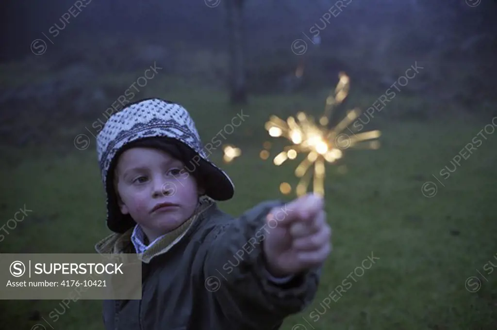 A boy holding a sparkler. Sweden
