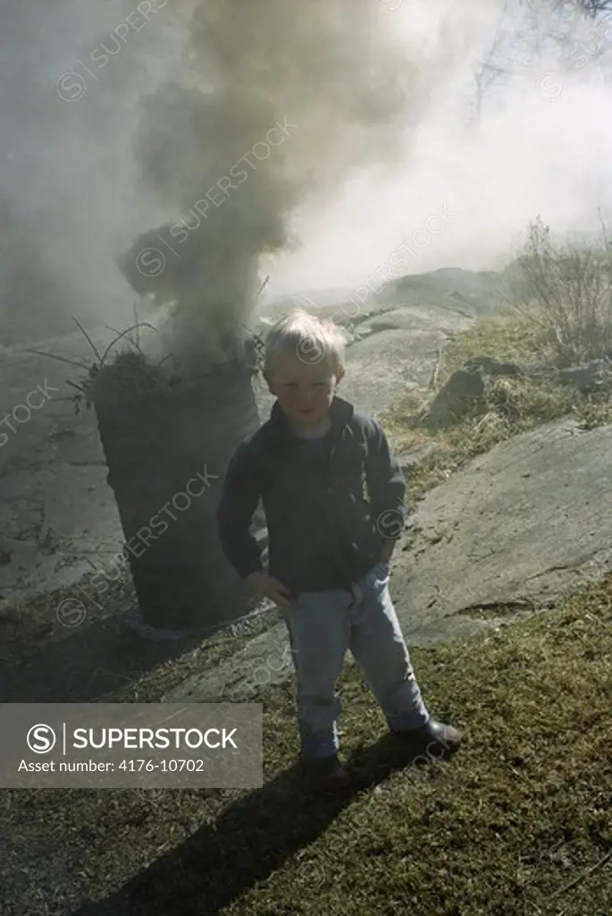 A boy burning last year's leaves. Sweden