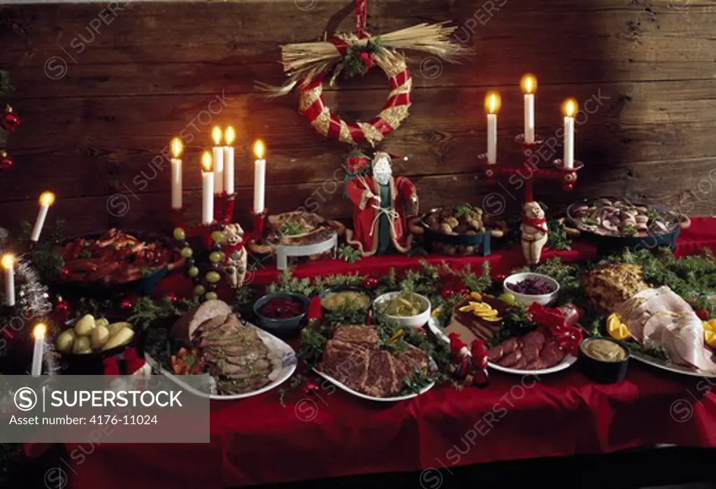 Dining table with christmasfood and lit candles